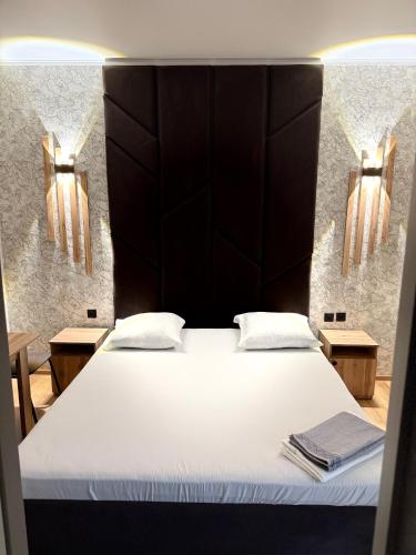 a bedroom with a large bed with a black headboard at Adel in Almaty