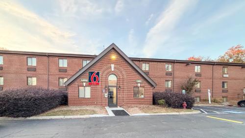 a large red brick building with a sign on it at Studio 6 Suites Greenville, SC - Haywood Mall in Greenville