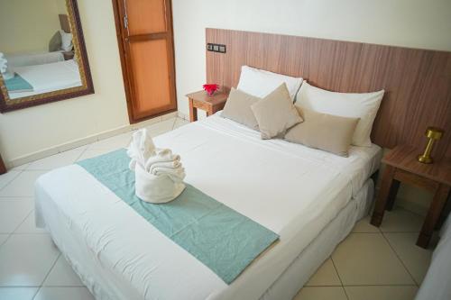 a bed with a pair of white shoes on it at Apparts-hôtel ISNI in Agadir