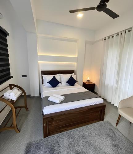 a bedroom with a bed and a chair in it at City Hotel Thalawathugoda in Talawatugoda
