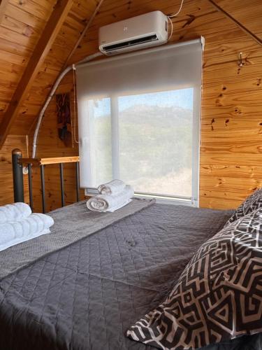 a bedroom with a bed and a window in a cabin at La Loica in El Maitén