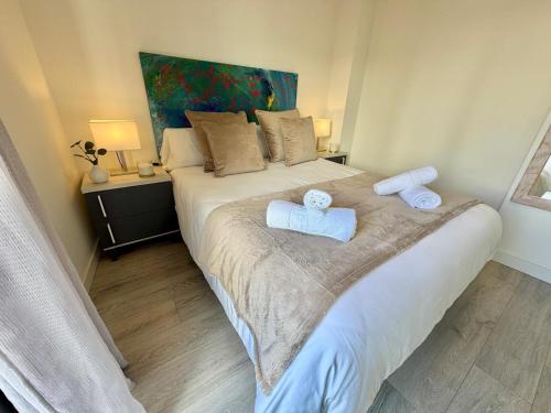 a bedroom with a bed with two towels on it at Apartamentos Rincón del Mar in Torre del Mar