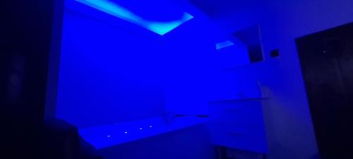 a blue bathroom with a tub and a sink at Chambre bain balneo indépendante in Valréas