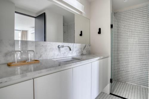 a white bathroom with a sink and a mirror at Tabas - Renata Edifício - Vila Buarque in São Paulo