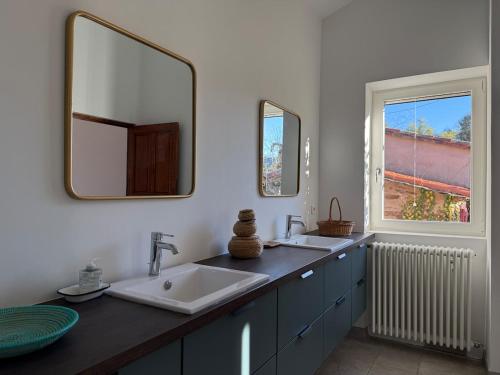 a bathroom with a sink and a mirror and a window at La Bellevue in Valleraugue