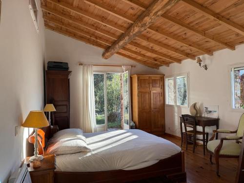 a bedroom with a bed and a desk and a window at La Bellevue in Valleraugue