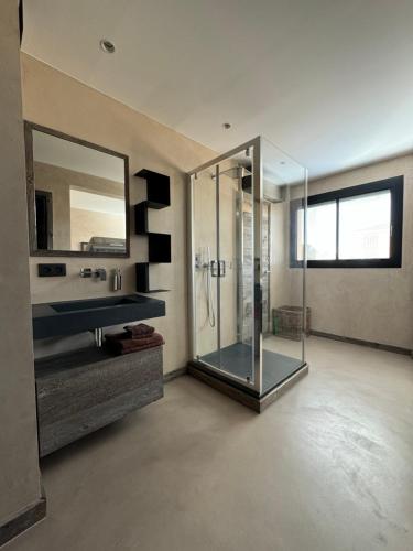 a bathroom with a glass shower and a sink at Port de Hyères Terrasse vue mer parking privé 2 SDB plage à pied in Hyères