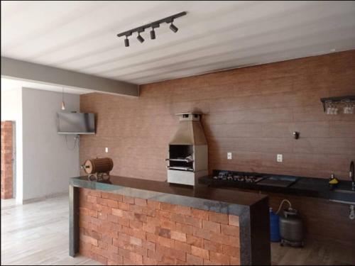 a kitchen with a brick wall and a stove at Sitio Vila Monte Verde in Jaboticatubas