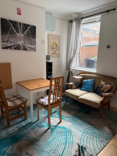 a living room with a couch and a table and chairs at Luton Town Homestay - Near AIRPORT & Train Station, High Speed Internet in Luton