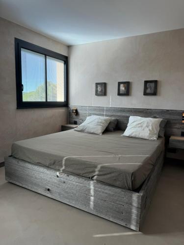 a large bed in a bedroom with a window at Port de Hyères Terrasse vue mer parking privé 2 SDB plage à pied in Hyères