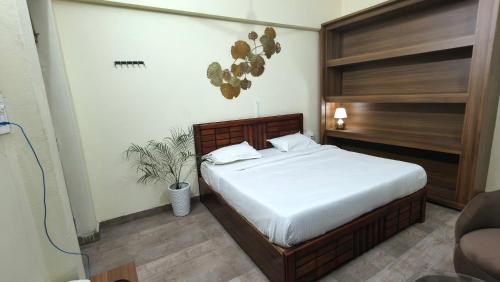 a bedroom with a bed with a wooden headboard at Amara Homestays in Prayagraj