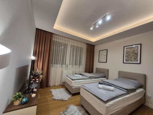a bedroom with two beds and a table at Apartamenty Zajazd u Marcela in Tuchola