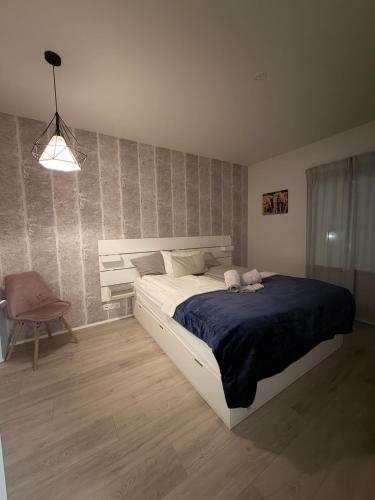 a bedroom with a large bed and a chair at Cozy ocean front apartment in Reykjavík