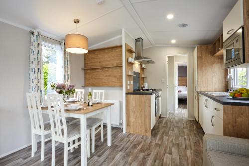 a kitchen and dining room with a table and chairs at Braidhaugh Holiday Lodge and Glamping Park in Crieff