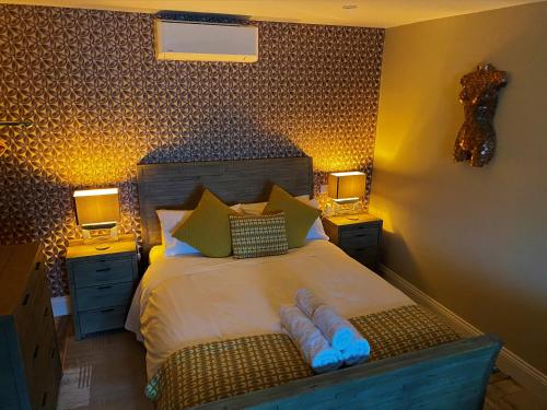 a bedroom with a large bed with two night stands at The View, Luxury studio in Curbar