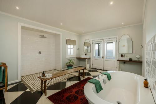 a large bathroom with a tub and a table at Camp Figtree by The Oyster Collection in Addo