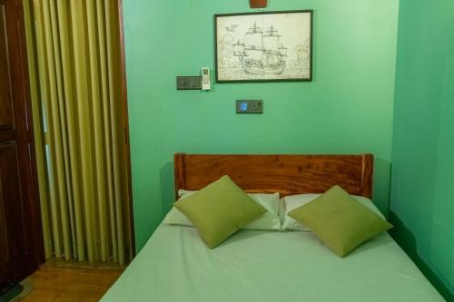 a green bedroom with a bed with two green pillows at Rose Villa by Kananke Hills in Kananke