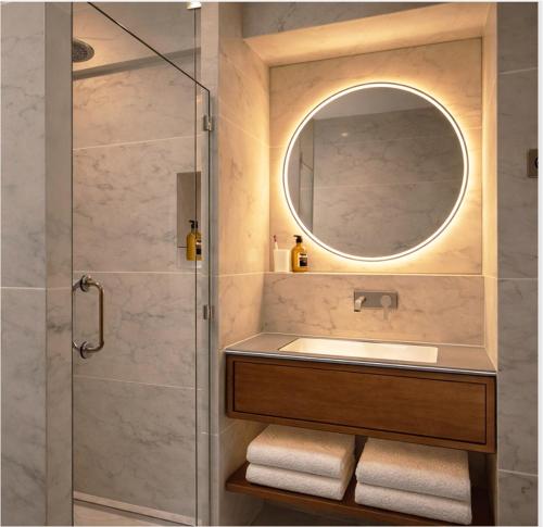 a bathroom with a shower with a sink and a mirror at Hotel Saint Cyr Etoile in Paris
