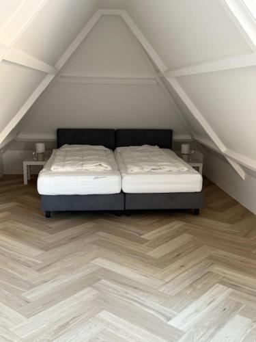 a bedroom with a bed in a attic at Studio 14 in Nes