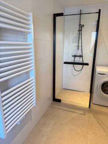 a laundry room with a window and a washing machine at Studio 14 in Nes