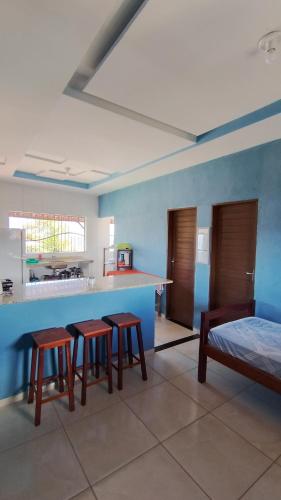 a kitchen with three stools and a counter in a room at Hostel Casa da Cida II in Pipa