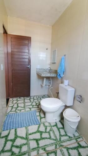 a bathroom with a toilet and a sink at Hostel Casa da Cida II in Pipa
