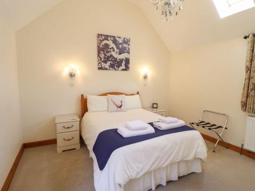 a bedroom with a bed with two towels on it at The Stables in Louth