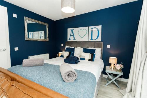 a bedroom with a large bed with blue walls at Annabelle's Den in Gatehouse of Fleet