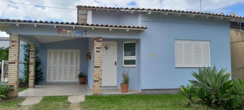 a blue and white house with a porch at Pantano Casa da Fafá e do Dila in Pântano Grande