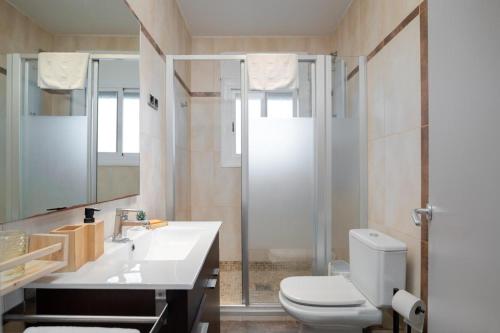 a bathroom with a toilet and a sink and a shower at Mima House with Pool in Canyelles