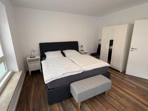 a bedroom with a large bed and a ottoman at Centrally located in Coesfeld in Coesfeld