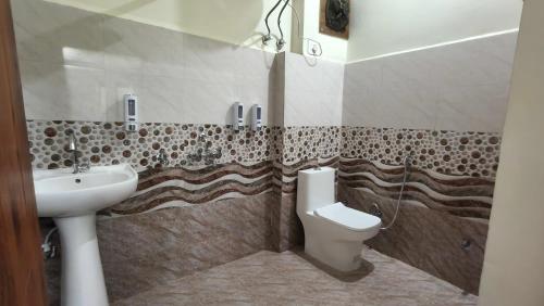 a bathroom with a sink and a toilet at Amara Homestays in Prayagraj
