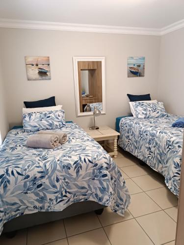 a bedroom with two beds and a mirror at J&B Tuiste in Reebok