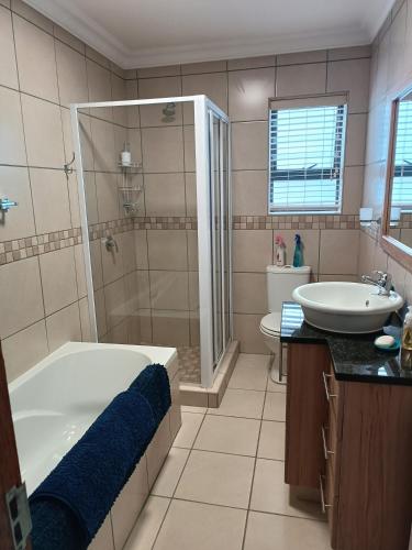 a bathroom with a tub and a sink at J&B Tuiste in Reebok