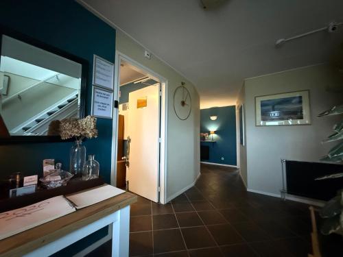 a room with a hallway with a mirror and a door at B&B Plompetorenzicht in Burgh Haamstede