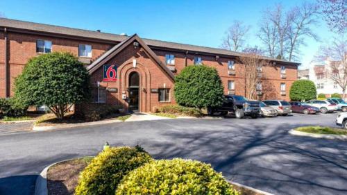 a large brick building with cars parked in front of it at Studio 6 Suites Charlotte, NC - Tyvola Rd Executive Park in Charlotte