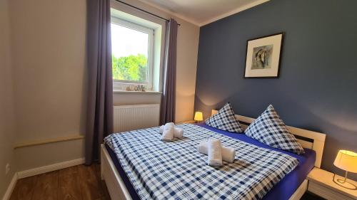 a bedroom with a blue and white bed with a window at 09 Gänseweide - Hof Wiesengrund in Parchtitz
