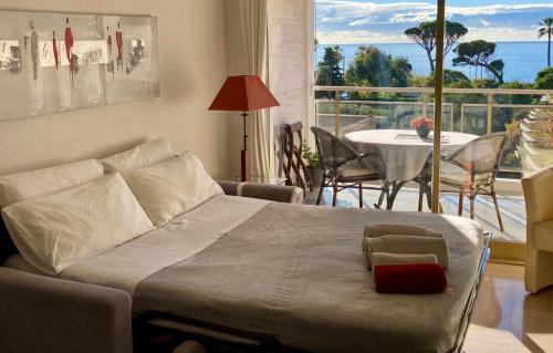 a bedroom with a bed with a table and a balcony at Cannes Events, Beach, Pool & Parking in Cannes