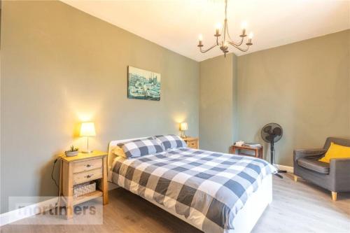 a bedroom with a bed and a chair at Spacious 2 Bed Ribble Valley Apartments in Blackburn