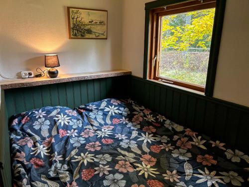 ein Schlafzimmer mit einem Bett und einem Fenster in der Unterkunft Farmstay Götes Cabin, 2p in Årjäng