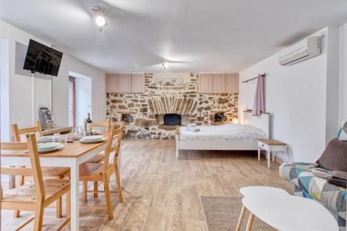 a living room with a table and a fireplace at Les gîtes du Gauliat in Espartignac