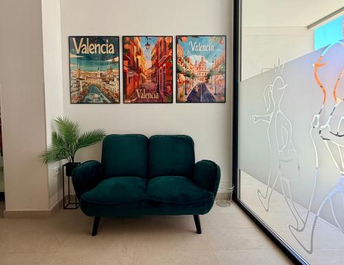 a green couch in a room with posters on the wall at STUDIO Palomar - PalomarGroup in Alfara del Patriarca