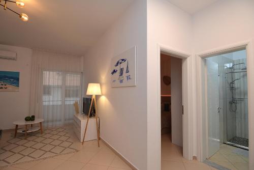 a white room with a shower and a lamp at All Seasons Apartment in Durrës