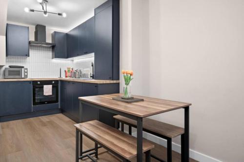 a kitchen with a table with a vase of flowers on it at 2BR Apartment in Cardiff’s Vibrant Roath in Cardiff