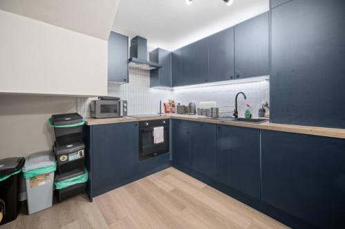a kitchen with blue cabinets and a counter top at 2BR Apartment in Cardiff’s Vibrant Roath in Cardiff