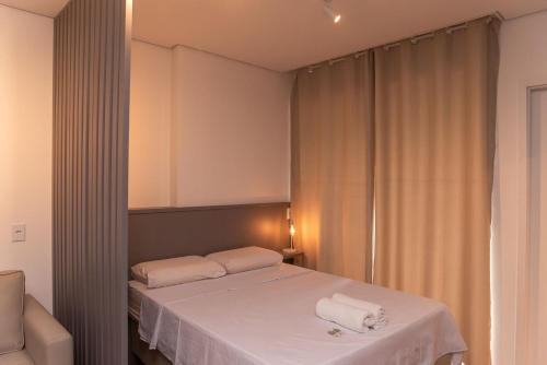 a bedroom with a bed with two towels on it at Flat 400m da UFV 650m da Rodoviária in Viçosa