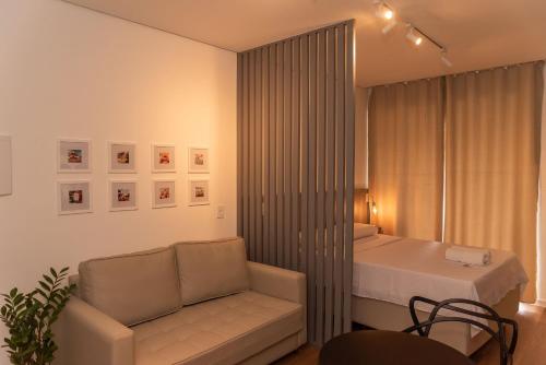 a bedroom with a bed and a chair and a couch at Flat 400m da UFV 650m da Rodoviária in Viçosa