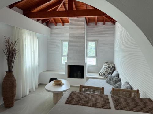a living room with a table and a fireplace at Nafsika Residences ex Petra Mare Village in Kerveli