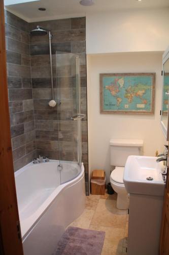 a bathroom with a tub and a toilet and a sink at Snowdon View in Llanberis
