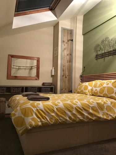 a bedroom with a bed with a large yellow comforter at Snowdon View in Llanberis